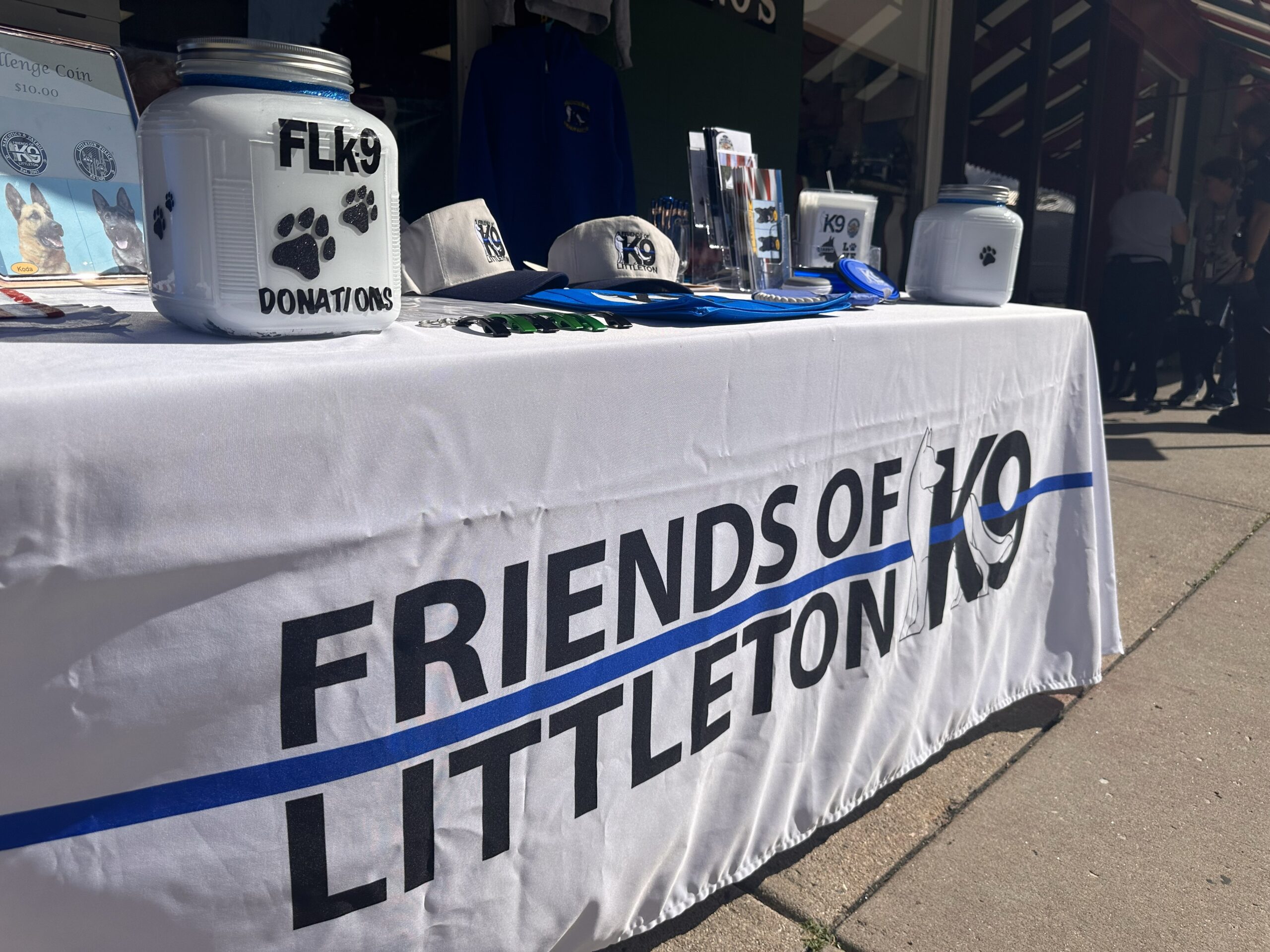 Table setup for Friends of Littleton K9 with dog-related items.