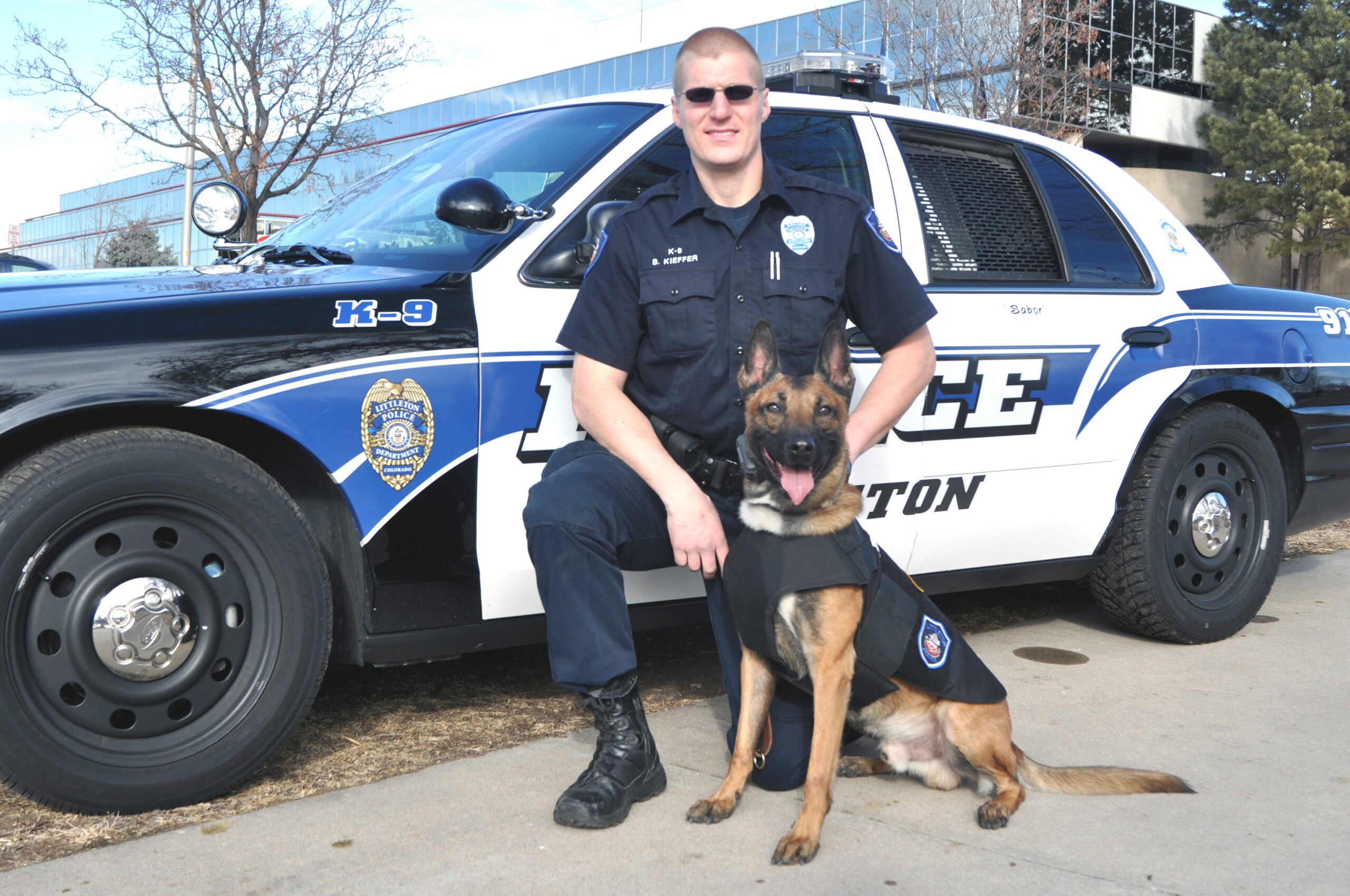 Police officer posing with a German Shepherd police dog.