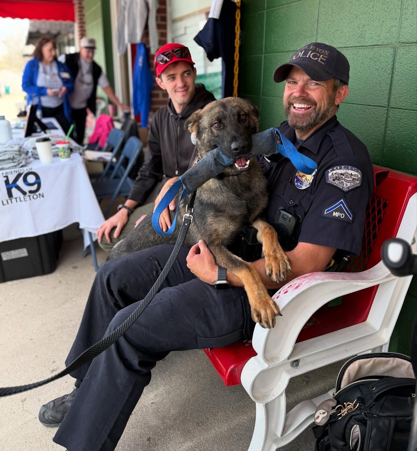 Police officer with a K9 dog at a community event.